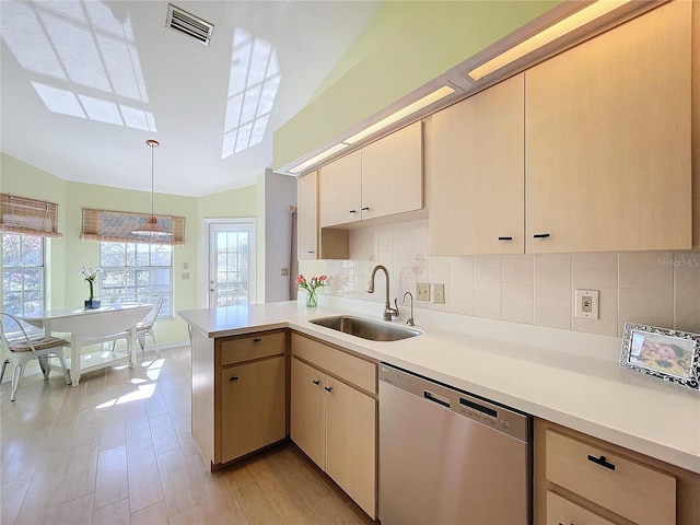 kitchen featuring a sink, tasteful backsplash, light countertops, and dishwasher