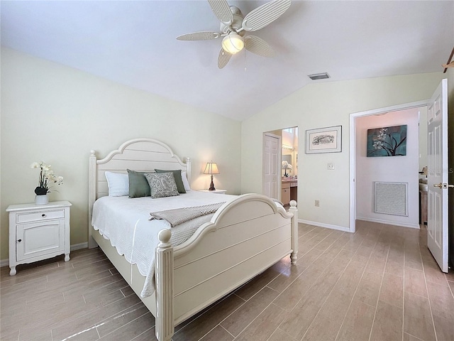 bedroom featuring light wood finished floors, visible vents, and vaulted ceiling