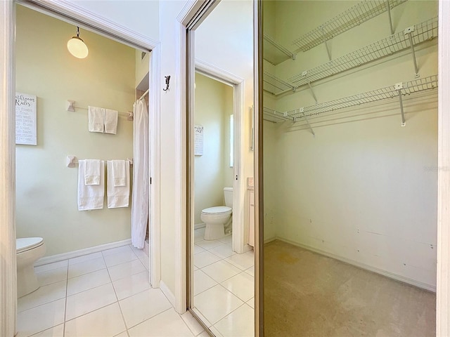 full bath with tile patterned flooring, baseboards, a spacious closet, and toilet