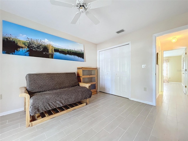 living area with visible vents, ceiling fan, baseboards, and wood finished floors