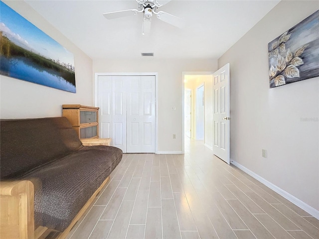 sitting room featuring visible vents, ceiling fan, baseboards, and wood finished floors