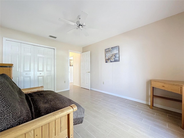 bedroom with a ceiling fan, visible vents, baseboards, a closet, and light wood finished floors