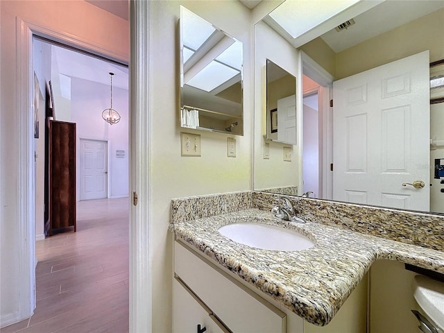 bathroom with vanity, wood finished floors, and visible vents