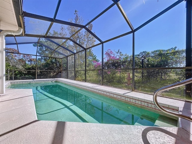 outdoor pool featuring glass enclosure and a patio