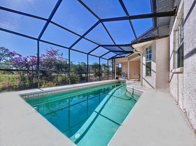 view of swimming pool with glass enclosure and a patio area