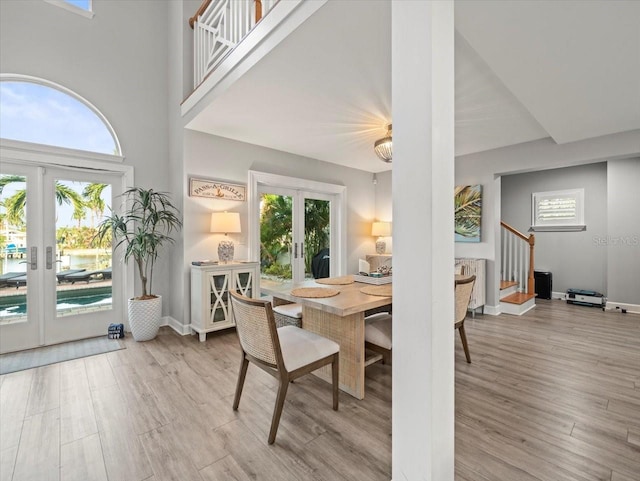 dining area with a healthy amount of sunlight, light wood-type flooring, and french doors