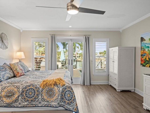 bedroom featuring wood-type flooring, access to outside, multiple windows, and ceiling fan