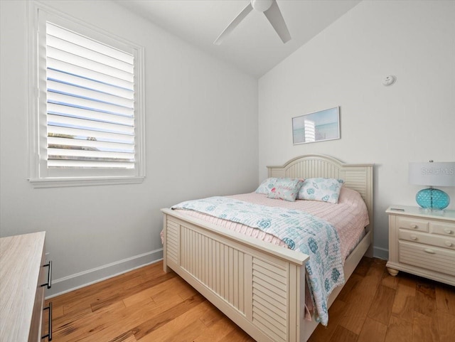 bedroom with ceiling fan, lofted ceiling, and light hardwood / wood-style flooring