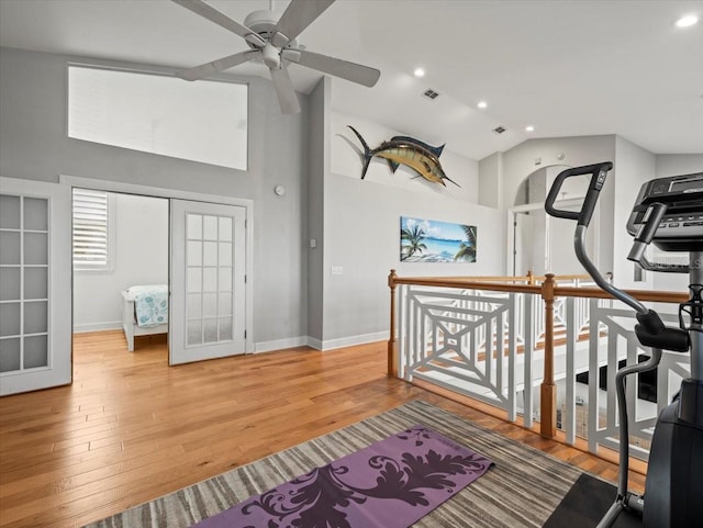 workout room featuring ceiling fan, french doors, vaulted ceiling, and hardwood / wood-style flooring