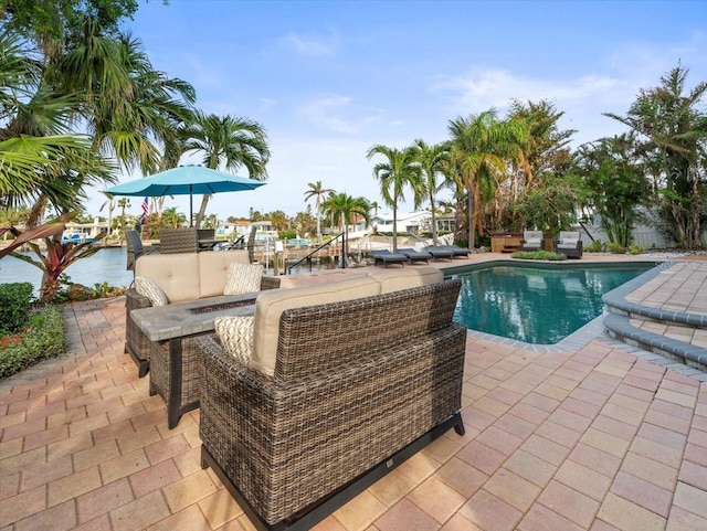 view of pool featuring a water view and a patio area