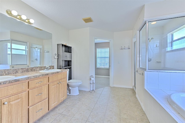 full bathroom with tile patterned flooring, separate shower and tub, toilet, and a wealth of natural light