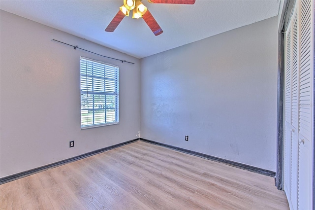 spare room with ceiling fan, light hardwood / wood-style floors, and a textured ceiling