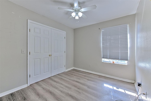 unfurnished bedroom with a closet, light hardwood / wood-style flooring, and ceiling fan