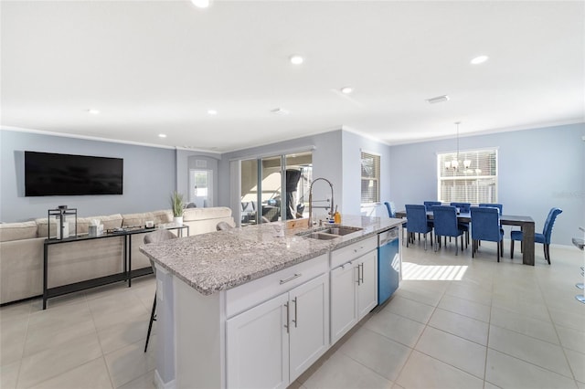 kitchen featuring a kitchen island with sink, sink, stainless steel dishwasher, light stone countertops, and white cabinetry