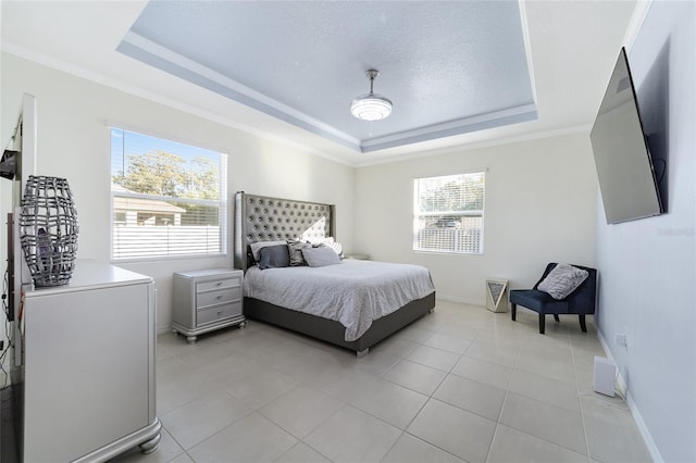 tiled bedroom with a textured ceiling, a raised ceiling, and crown molding