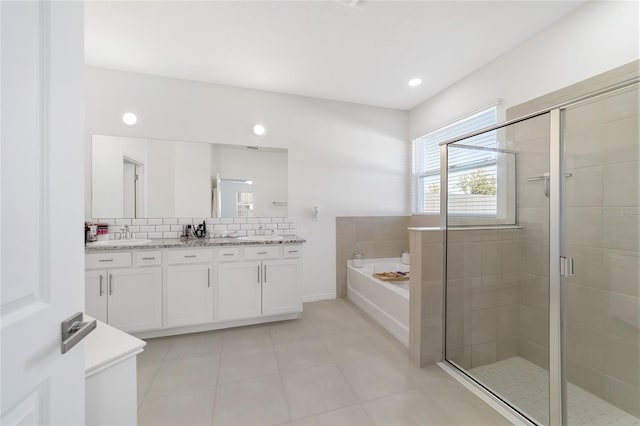 bathroom featuring vanity, backsplash, and independent shower and bath