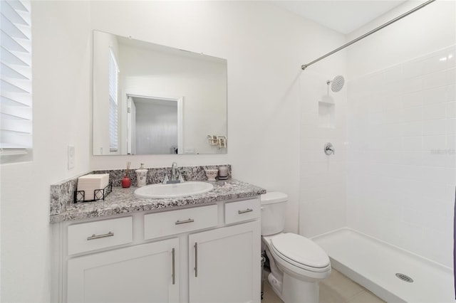 bathroom with tile patterned flooring, vanity, toilet, and walk in shower