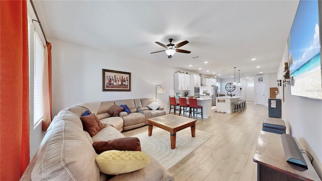 living room featuring ceiling fan and light wood-type flooring