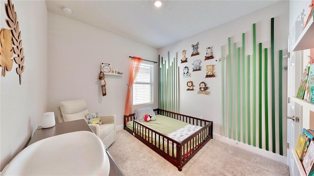 bedroom with a nursery area and light carpet