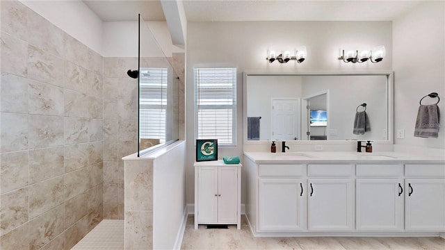 bathroom featuring tiled shower and vanity