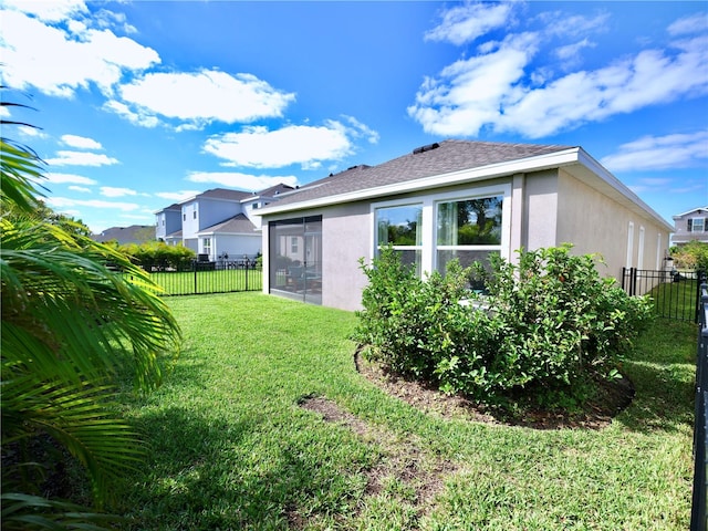 rear view of property featuring a yard and a sunroom