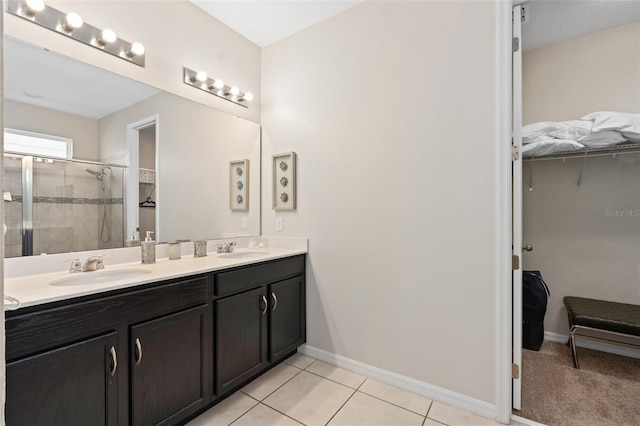 bathroom with tile patterned flooring, vanity, and a shower with door