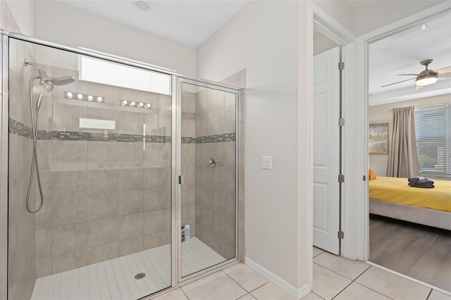 bathroom with tile patterned flooring, ceiling fan, and a shower with door