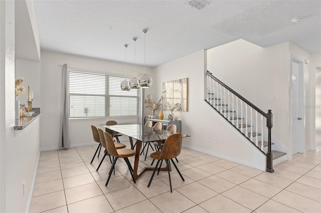 tiled dining area with a textured ceiling