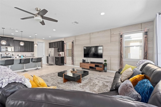 living room featuring ceiling fan and light tile patterned floors