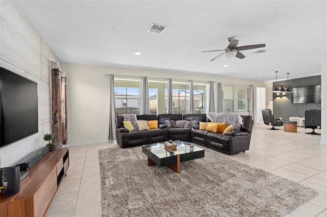 tiled living room with ceiling fan and a textured ceiling