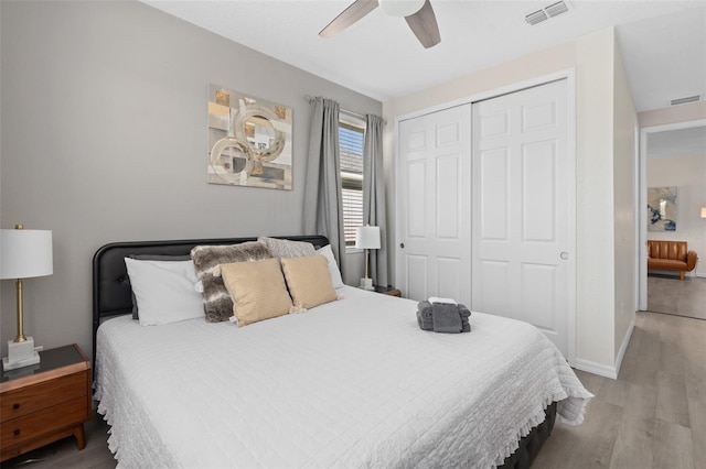 bedroom featuring ceiling fan, wood-type flooring, and a closet