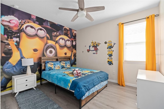 bedroom with a textured ceiling, light hardwood / wood-style floors, and ceiling fan