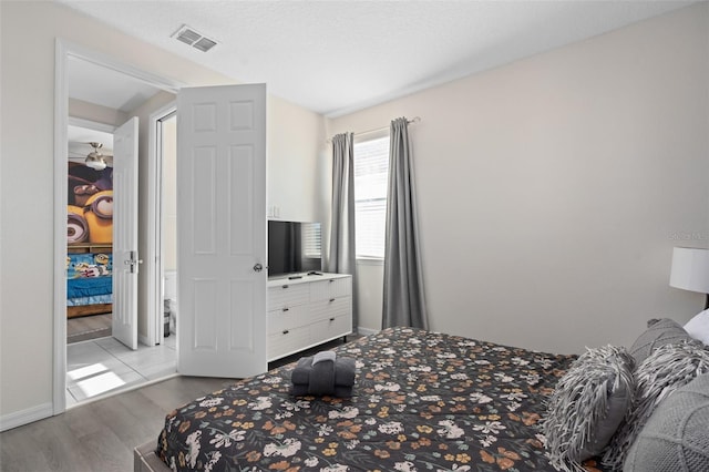 bedroom with light hardwood / wood-style flooring and a textured ceiling