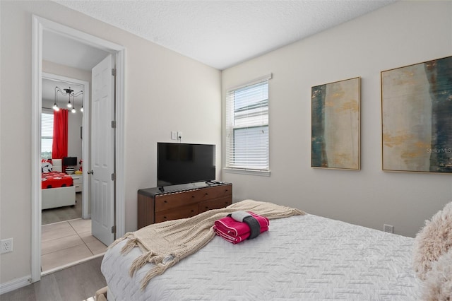 bedroom featuring light hardwood / wood-style flooring and a textured ceiling