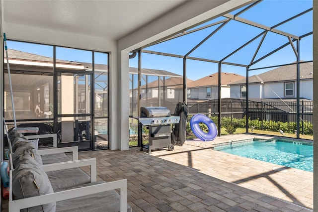 view of swimming pool with a lanai, a grill, and a patio