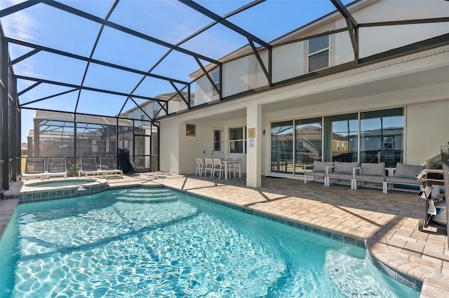 view of pool featuring an in ground hot tub, glass enclosure, and a patio area