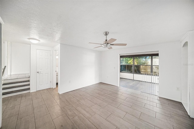 spare room with a textured ceiling, light wood-type flooring, and ceiling fan