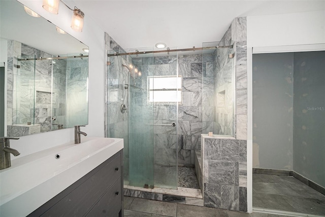 bathroom with tile patterned flooring, vanity, and walk in shower