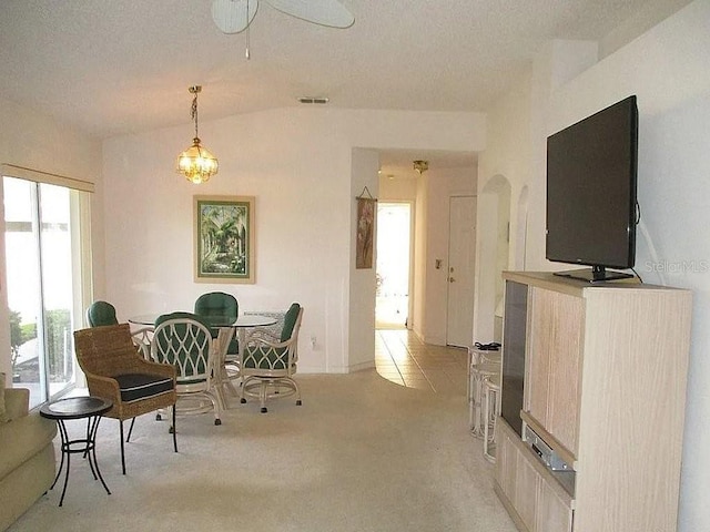 carpeted dining space featuring a chandelier, a textured ceiling, and vaulted ceiling