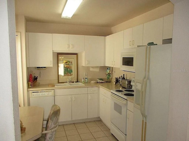 kitchen featuring sink, white appliances, white cabinetry, and light tile patterned flooring