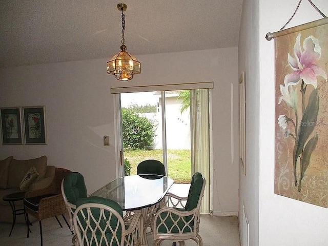 dining space featuring a textured ceiling, light colored carpet, vaulted ceiling, and a notable chandelier