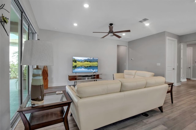 living room with ceiling fan and light hardwood / wood-style flooring