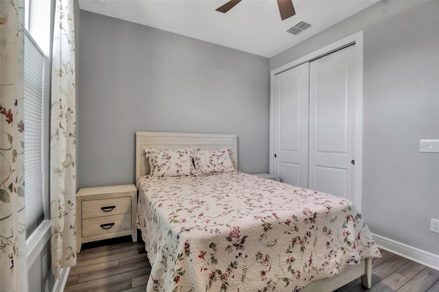 bedroom featuring dark wood-type flooring, a closet, and ceiling fan