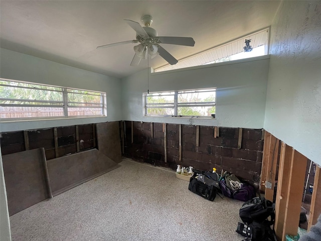 interior space featuring plenty of natural light, ceiling fan, light colored carpet, and lofted ceiling