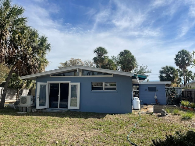 back of property with a yard and ac unit