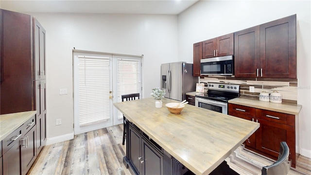 10543 Opus Dr, Riverview, FL 33579 - kitchen featuring stainless steel appliances, wood counters, light wood-style flooring, baseboards, and tasteful backsplash