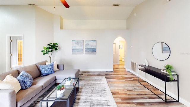 10543 Opus Dr, Riverview, FL 33579 - living room featuring arched walkways, ceiling fan, wood finished floors, baseboards, and high vaulted ceiling