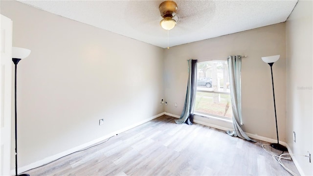 10543 Opus Dr, Riverview, FL 33579 - empty room with light wood finished floors, a ceiling fan, baseboards, and a textured ceiling