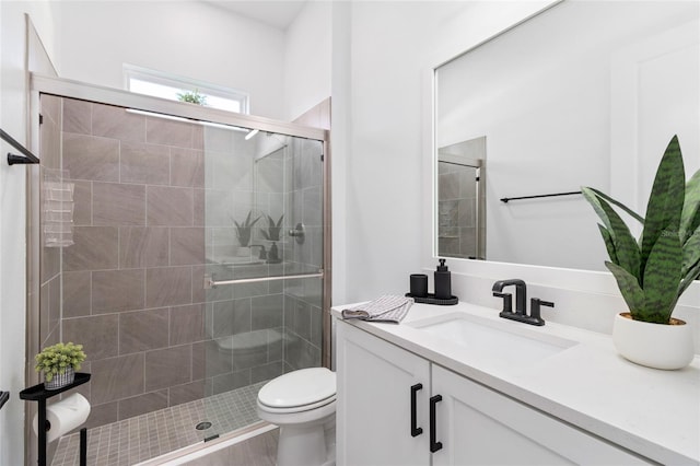 bathroom featuring vanity, toilet, and an enclosed shower