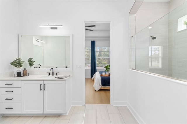 bathroom featuring tiled shower, vanity, ceiling fan, and tile patterned flooring